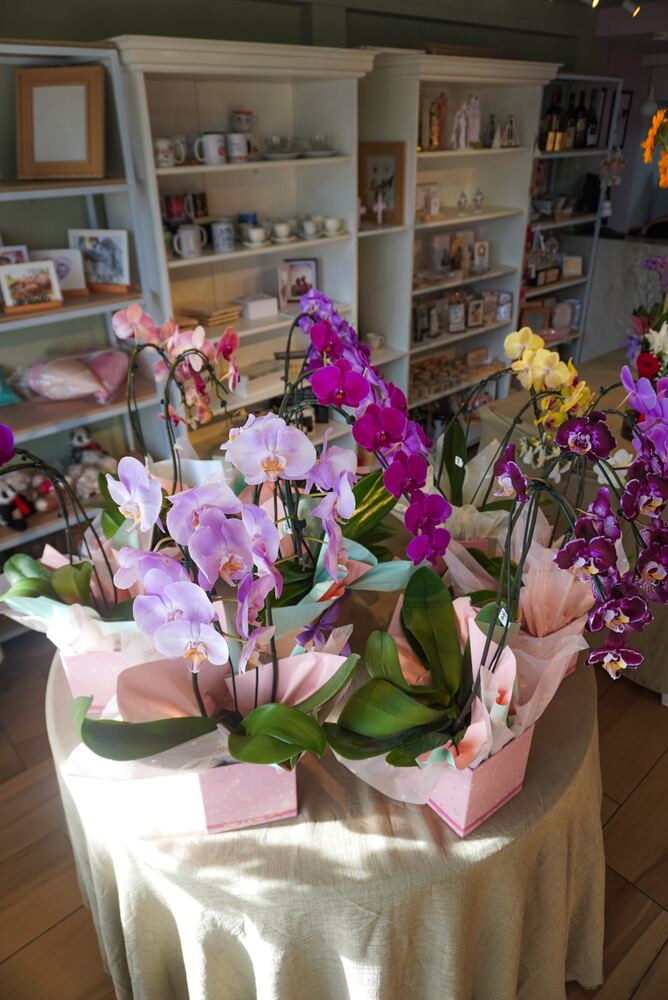 Cesta decorativa com flores variadas e itens de presente